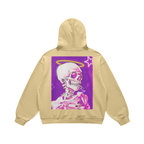 Felpa beige con cappuccio e stampa posteriore di uno scheletro rosa con alone giallo su sfondo viola con stelle